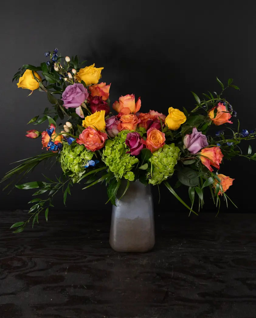 Colorful bouquet of flowers in a vase on a dark background