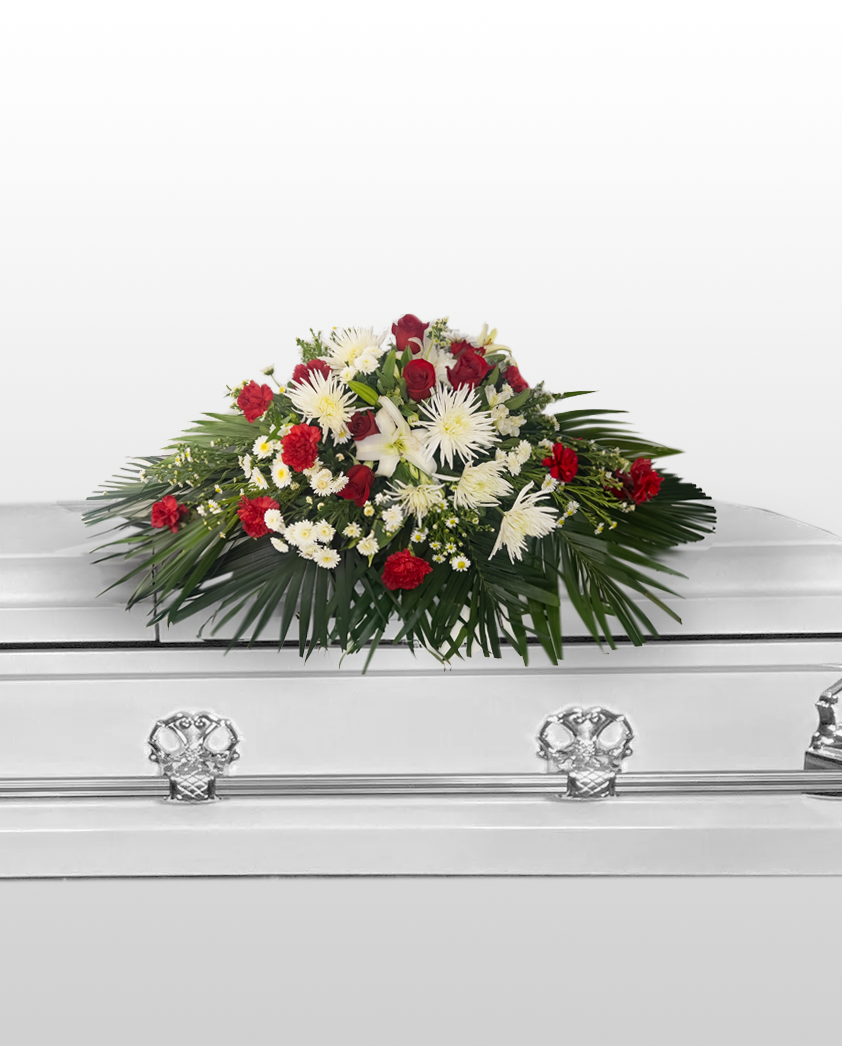 casket spray arrangement on a white casket with a plain background
