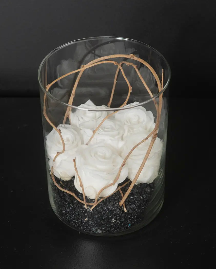 Glass vase with white flowers and branches on a black background