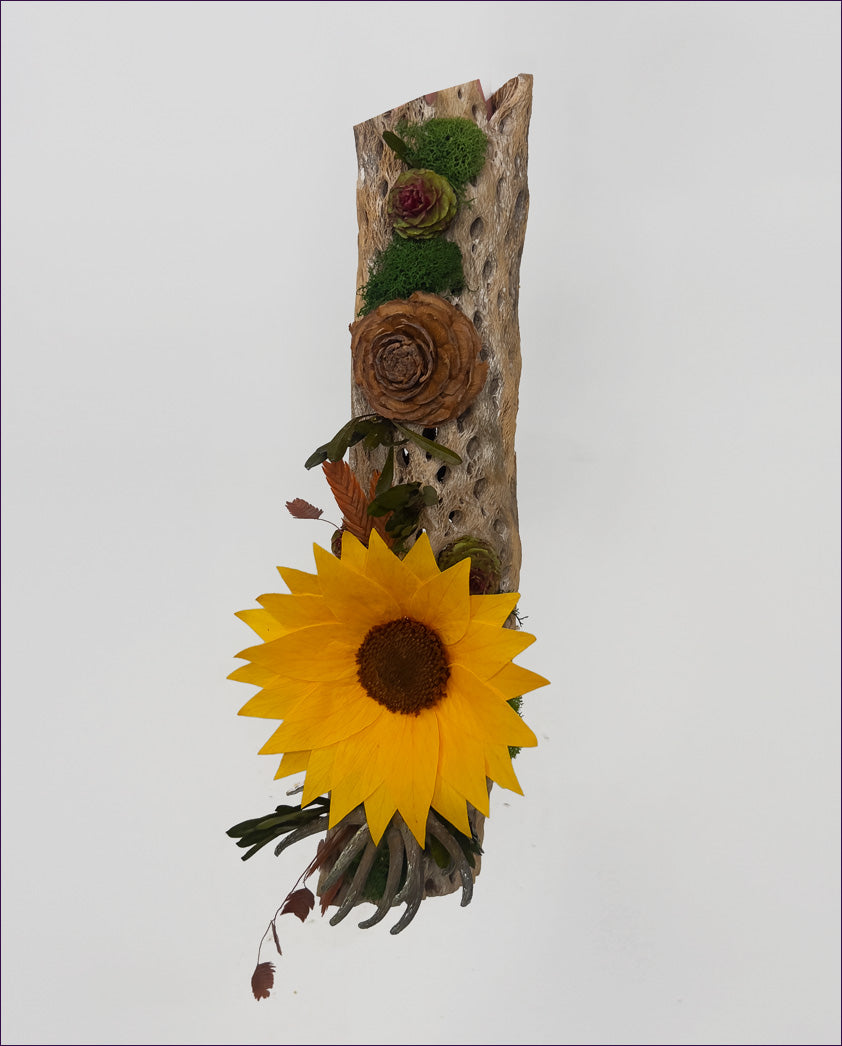 Decorative piece with sunflower, roses, and greenery on a white background