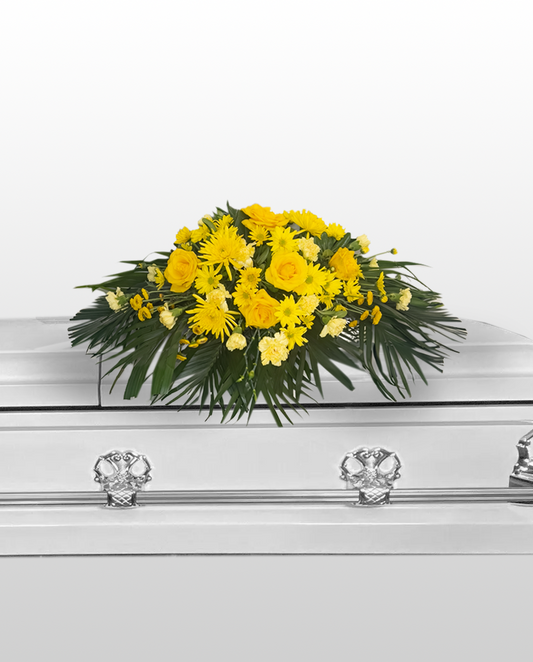 yellow floral casket spray arrangement on a white background