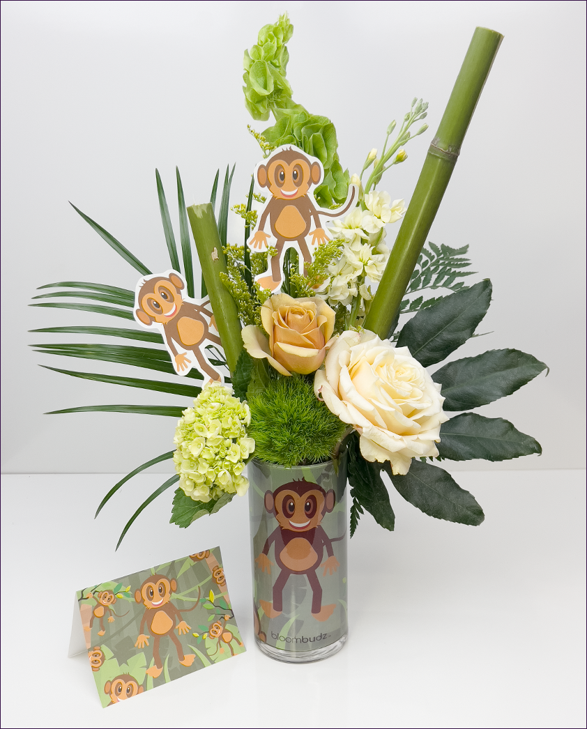 Floral arrangement with monkey-themed decorations on a white background