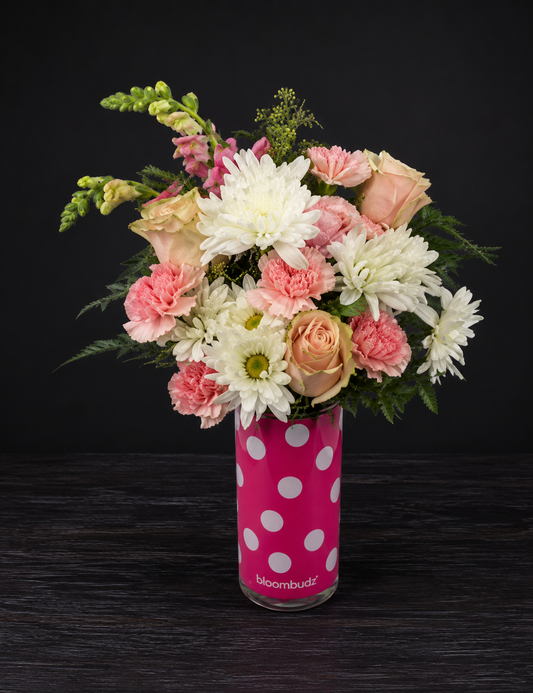 Floral arrangement in a polka dot vase on a dark background