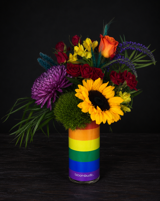 Colorful bouquet in a rainbow-striped vase on a black background