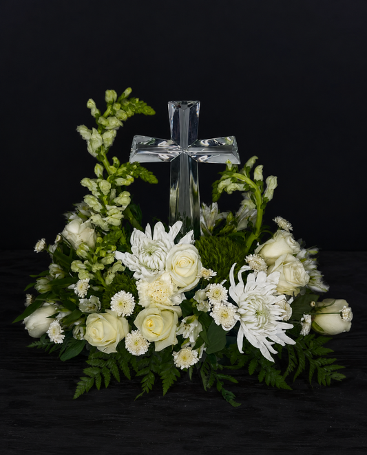 Floral arrangement with a crystal cross on a black background