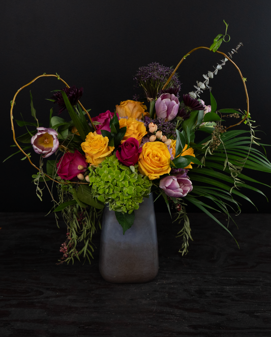 Colorful flower arrangement in a vase on a dark background