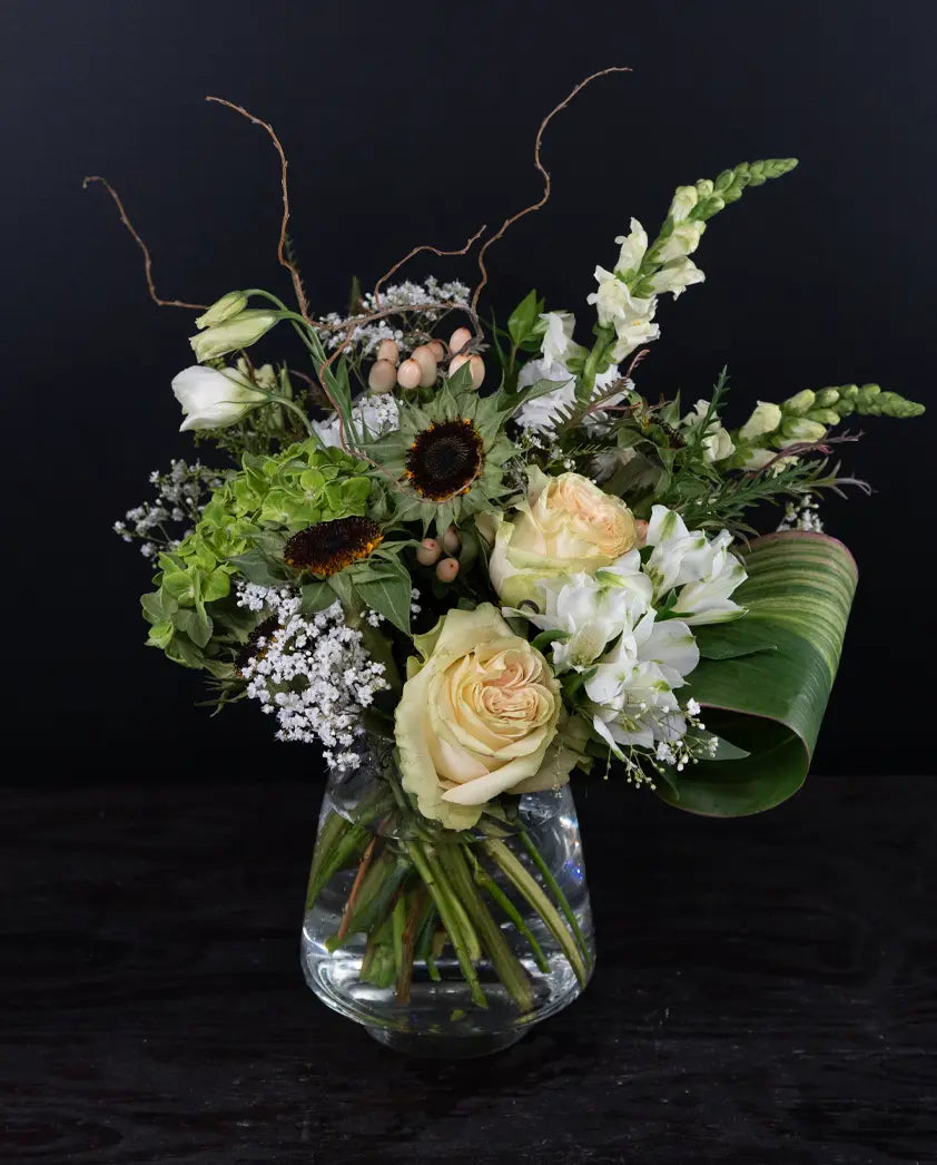 Floral arrangement in a clear vase on a black background