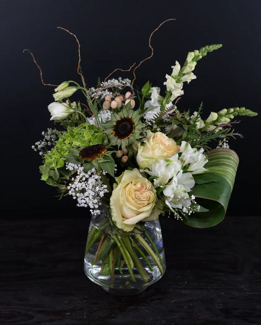 Floral arrangement in a clear vase on a black background