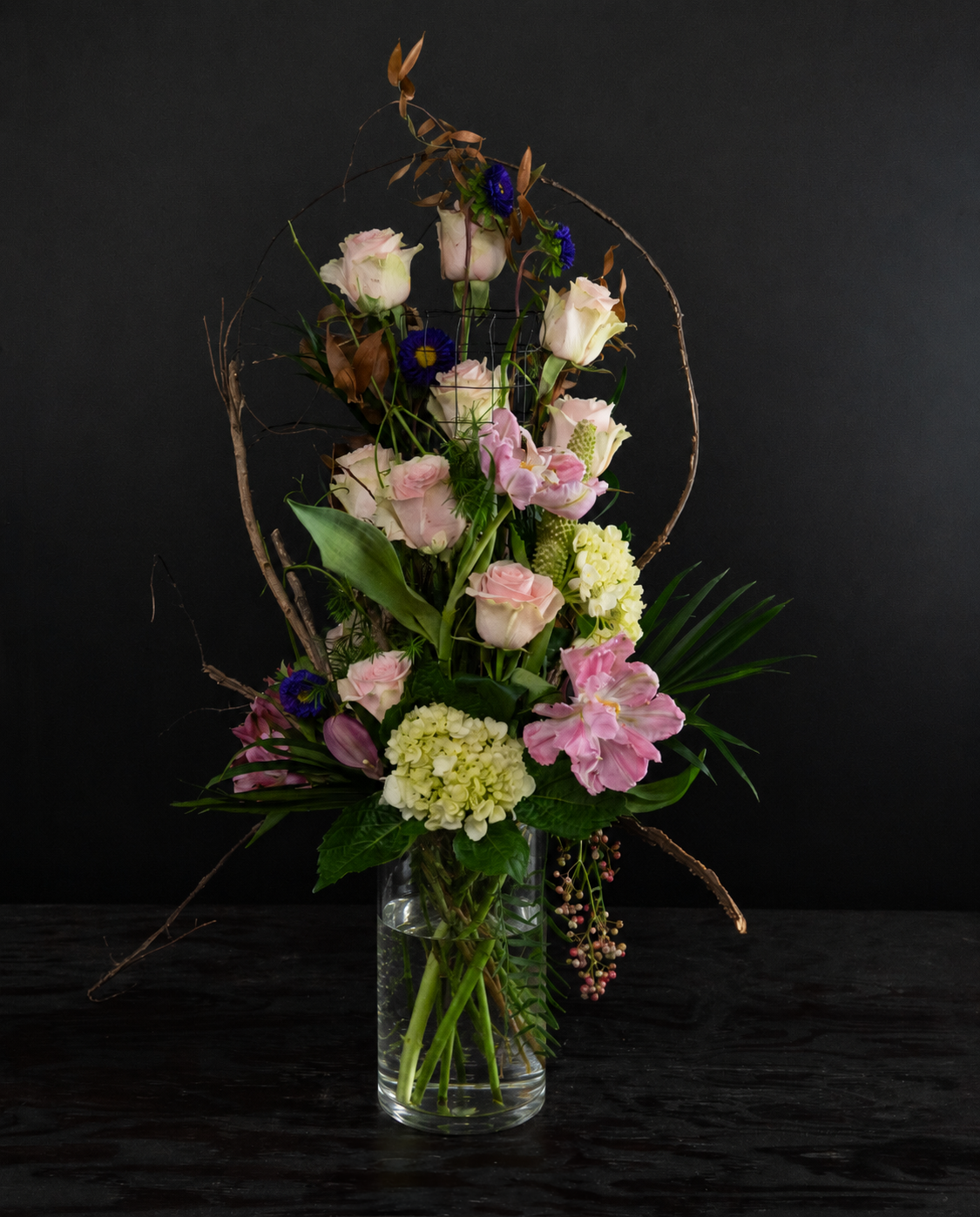 Floral arrangement in a clear vase on a black background